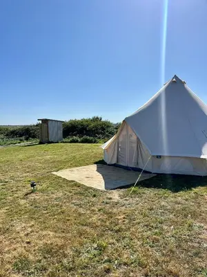 a white tent sitting in a field of grass at Tiny Treamble in Cubert