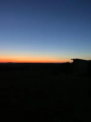 a view of the sunset from a field at Tiny Treamble in Cubert