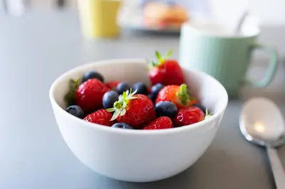 a bowl of strawberries and blueberries on a table at Trewirgie in St Ives