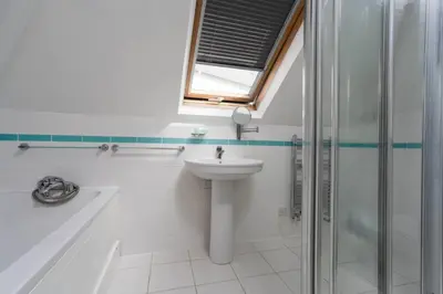 a white bathroom with a sink and a shower at Trewirgie in St Ives