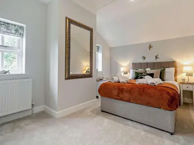 a bedroom with a large bed and a mirror at Rose Cottage in Saint Hilary