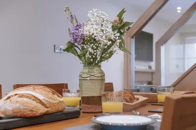 a vase of flowers and a loaf of bread on a table at Bluck's cottage in St. Agnes