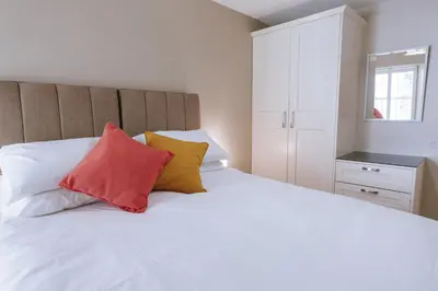 a bedroom with a white bed with four pillows at Bluck's cottage in St. Agnes