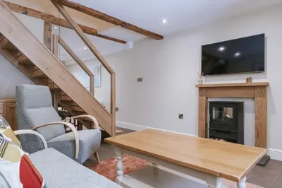 a living room with a table and a fireplace at Bluck's cottage in St. Agnes