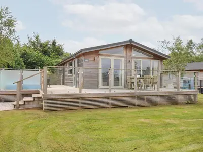 a large wooden house with a large deck at 3 Meadow Retreat in Liskeard