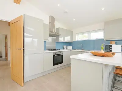 a kitchen with white appliances and blue walls at 3 Meadow Retreat in Liskeard