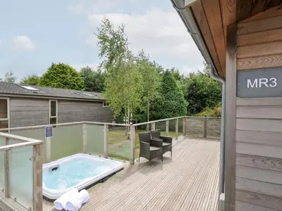 a deck with a jacuzzi tub on a house at 3 Meadow Retreat in Liskeard
