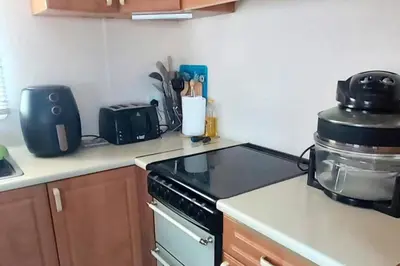 a kitchen with a stove and a counter top at 5Berth -Family Friendly -ParkingSpot -Heated Pool in St Austell
