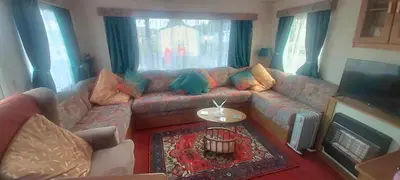 a living room with a couch and a television at 5Berth -Family Friendly -ParkingSpot -Heated Pool in St Austell