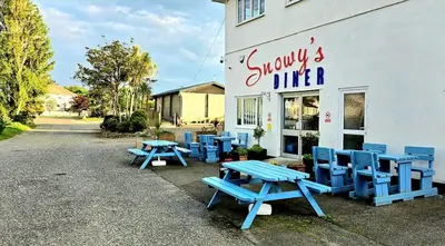a group of blue picnic tables in front of a store at 5Berth -Family Friendly -ParkingSpot -Heated Pool in St Austell