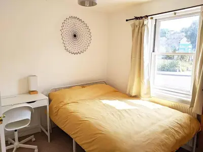 a bedroom with a bed and a desk and a window at Private self-contained double bed & ensuite in Penryn