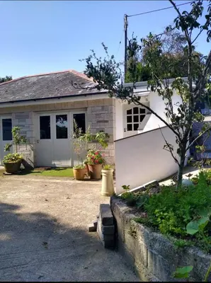 a white house with a white fence in front of it at The Birch House in Saint Columb Major