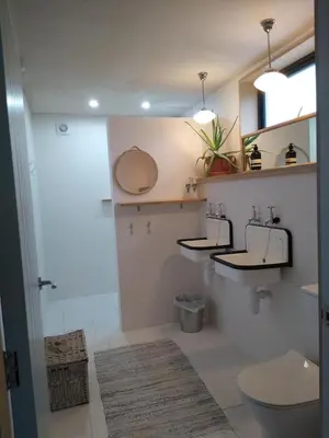 a bathroom with two sinks and a toilet at The Birch House in Saint Columb Major