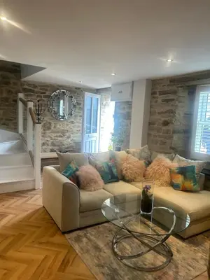 a living room with a couch and a glass table at Honeysuckle Cottage in St. Agnes