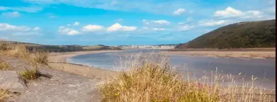 a view of a beach with mountains in the background at 204 Atlantic Bays, St Merryn in St Merryn