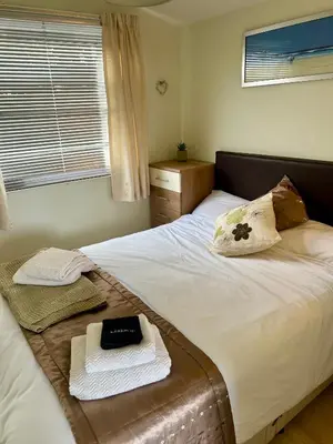 a bedroom with a bed with towels and a window at 204 Atlantic Bays, St Merryn in St Merryn