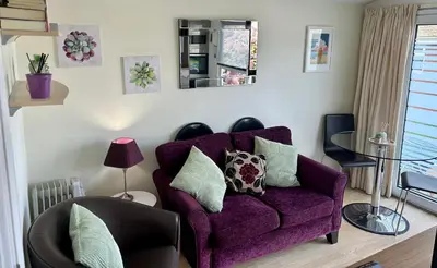 a living room with a purple couch with pillows at 204 Atlantic Bays, St Merryn in St Merryn
