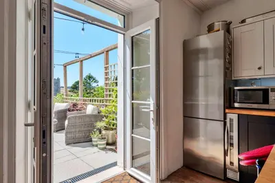 a kitchen with a sliding glass door leading to a patio at Finest Retreats - The Old Vicarage in Talland