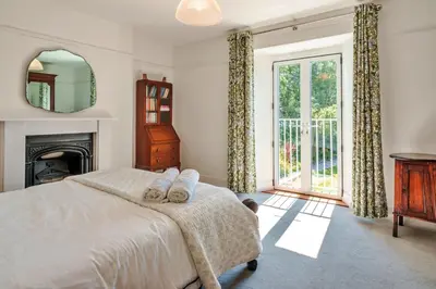 a bedroom with a bed and a fireplace at Finest Retreats - The Old Vicarage in Talland