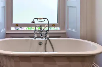 a bath tub in a bathroom with a window at Finest Retreats - The Old Vicarage in Talland
