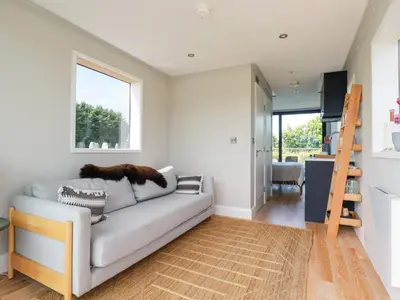 a living room with a couch and a window at Riverside Exclusive Retreat in Newquay