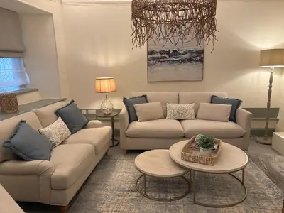 a living room with two couches and a table at Merchants House in Penryn