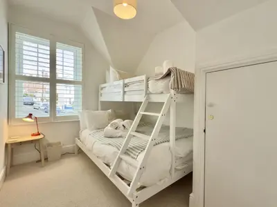 a bedroom with a white bunk bed and a desk at 1 Netherton in Padstow