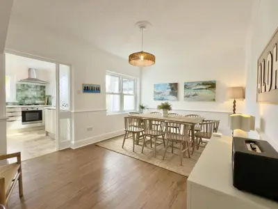 a dining room and living room with a table and chairs at 1 Netherton in Padstow