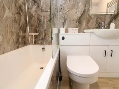 a bathroom with a toilet and a tub and a sink at St Marys in Penzance