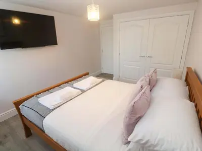 a bedroom with two beds and a flat screen tv at St Marys in Penzance