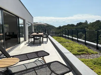 a patio with chairs and a table on a balcony at Skyfall in Downderry