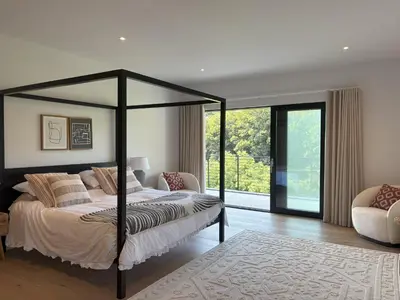 a bedroom with a bed and a large window at Skyfall in Downderry