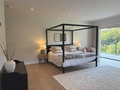 a bedroom with a bed and a large window at Skyfall in Downderry