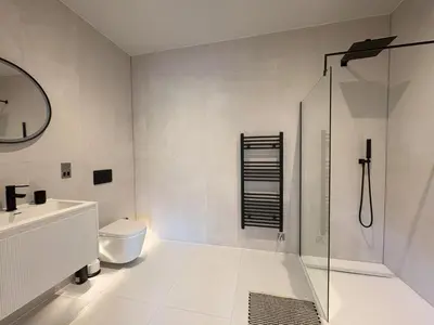 a bathroom with a shower and a toilet and a sink at Skyfall in Downderry