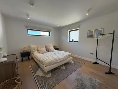 a bedroom with a bed in the middle of it at Skyfall in Downderry