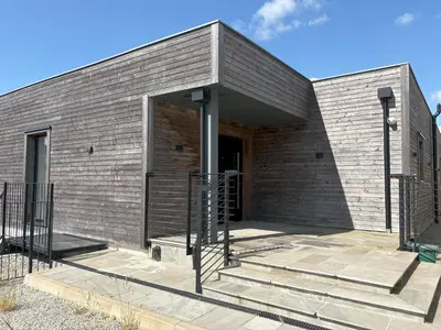 a brick building with a staircase in front of it at Skyfall in Downderry