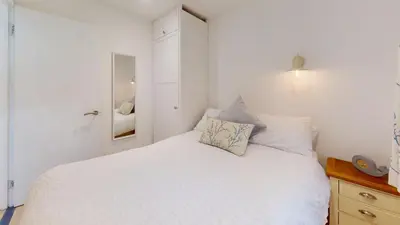 a bedroom with a white bed and a mirror at St Ives Kornel Hewel 2 Bedrooms in St Ives