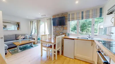 a kitchen and living room with a couch and a table at St Ives Kornel Hewel 2 Bedrooms in St Ives