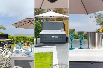 a table with glasses and a grill with an umbrella at Mor Glas in Carbis Bay