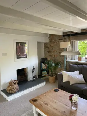 a living room with a couch and a fireplace at April Cottage in Saint Erth