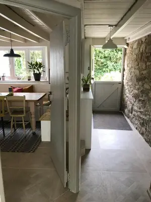 a kitchen and dining room with a stone wall at April Cottage in Saint Erth
