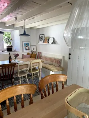a dining room and living room with a table and chairs at April Cottage in Saint Erth