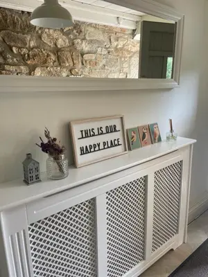 a white fireplace with a happy place sign on it at April Cottage in Saint Erth