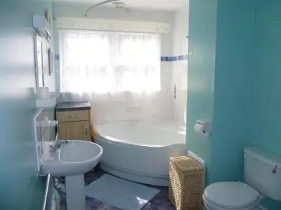 a bathroom with a tub and a sink and a toilet at 9 Rock Towers in Looe