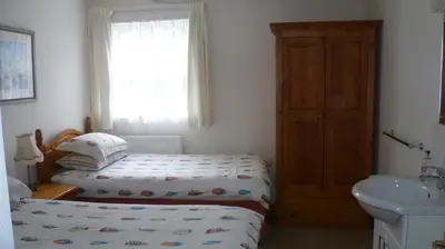 a small bedroom with a bed and a sink at 9 Rock Towers in Looe