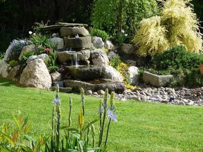 a garden with a stone fountain in the grass at Copper Meadow in Launceston