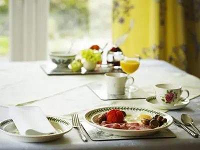 a table with a plate of eggs and fruit on it at Copper Meadow in Launceston