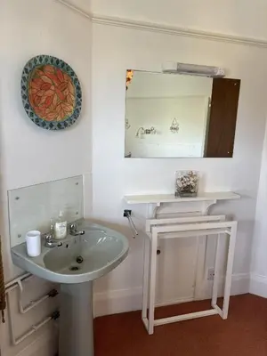 a bathroom with a sink and a mirror at Cowrie, New Polzeath in Wadebridge