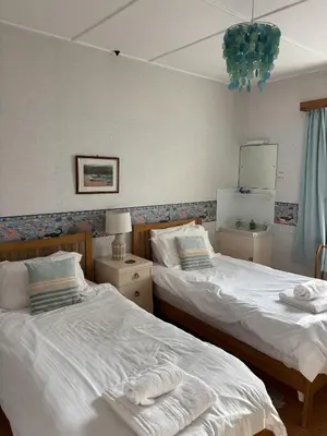 a bedroom with two beds and a mirror at Cowrie, New Polzeath in Wadebridge