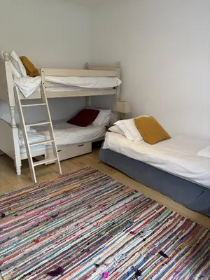 a room with two bunk beds and a rug at Cowrie, New Polzeath in Wadebridge